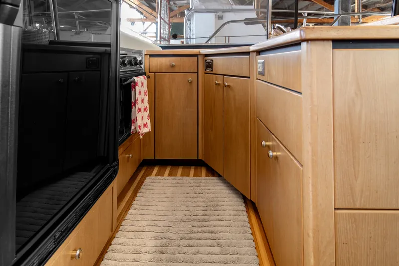 Slide: The Image of Interior of 2000 Bayliner 4087 Aft Cabin Motoryacht kitchen with wooden cabinets and appliances. - 15