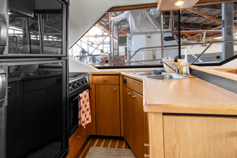 Slide: The Image of 2000 Bayliner 4087 Aft Cabin Motoryacht kitchen with wood cabinetry and modern appliances. - 13