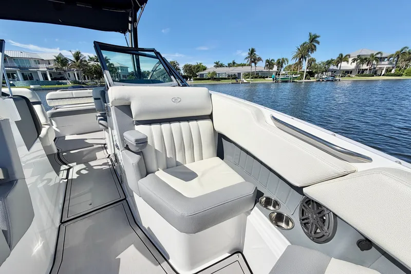 Slide: The Image of 2020 Cobalt 23SC boat interior with luxurious seating, docked by waterfront homes. - 22