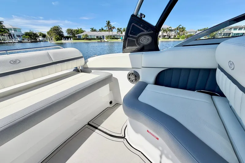 Slide: The Image of 2020 Cobalt 23SC boat interior with luxurious seating, overlooking a serene waterfront view. - 12