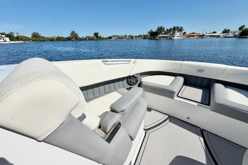Slide: The Image of 2020 Cobalt 23SC boat interior with luxurious seating on a sunny day by the water. - 24