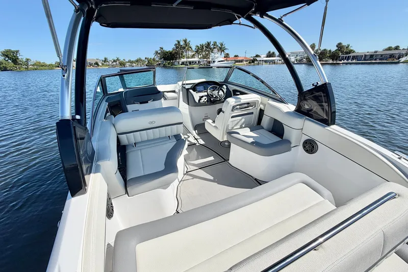 Slide: The Image of 2020 Cobalt 23SC boat interior with seating, steering wheel, and water view. - 8