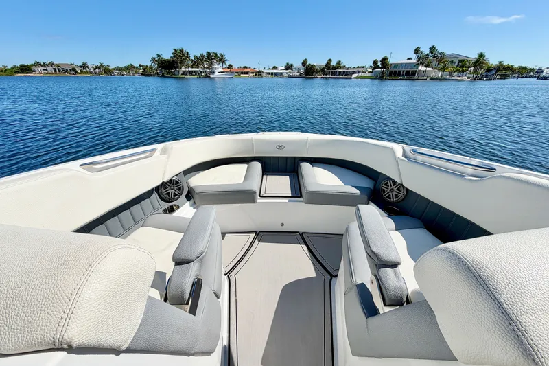 Slide: The Image of 2020 Cobalt 23SC boat interior with luxurious seating on a serene lake. - 23