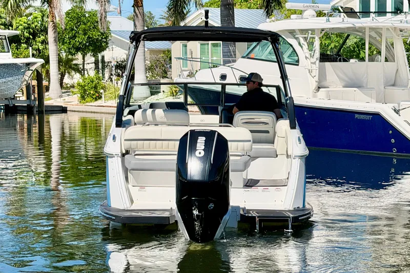 Slide: The Image of 2020 Cobalt 23SC boat with outboard motor in a sunny marina setting. - 2