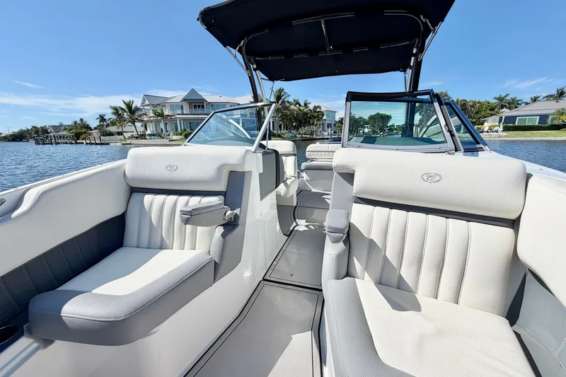 Slide: The Image of 2020 Cobalt 23SC boat interior with plush seating, on a sunny waterfront. - 20