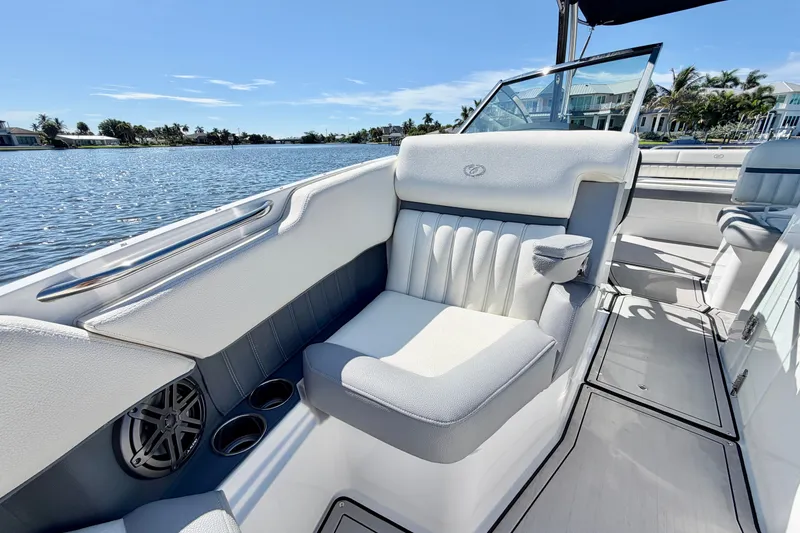 Slide: The Image of 2020 Cobalt 23SC boat interior with white seating, cup holders, and scenic water view. - 21
