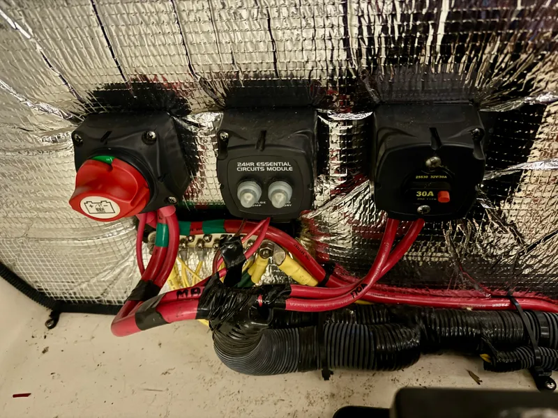 Slide: The Image of Close-up of electrical switches and wiring in a boat, surrounded by insulation material. - 38