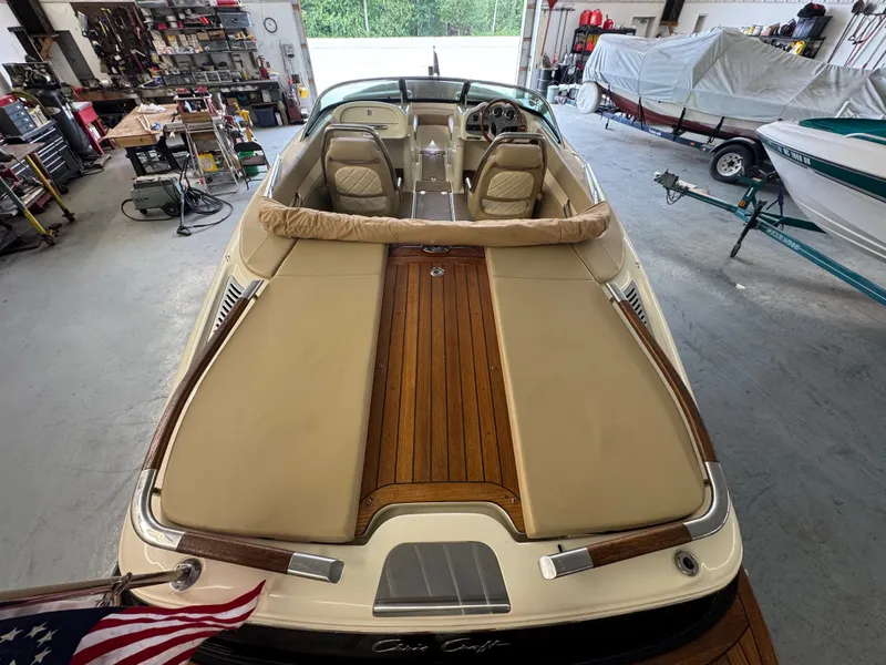 Slide: The Image of A 2016 Chris-Craft Carina 21 in a workshop. It features a sleek, classic design with wood accents. - 19