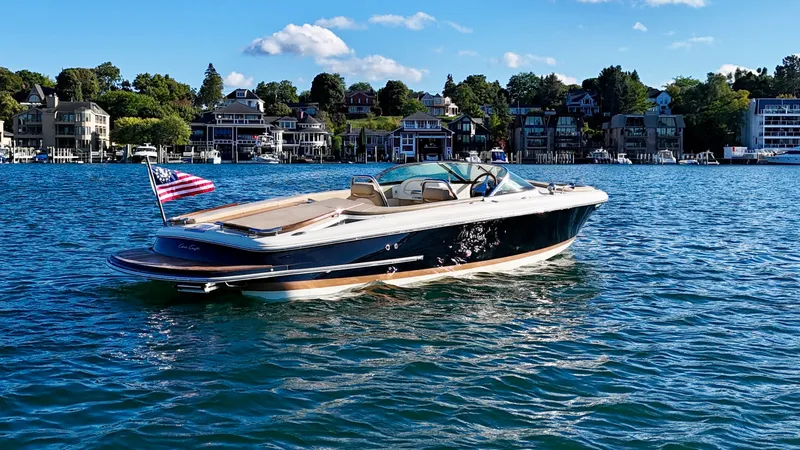 Slide: The Image of A 2016 Chris-Craft Carina 21 floats on calm water near a coastal town. - 15