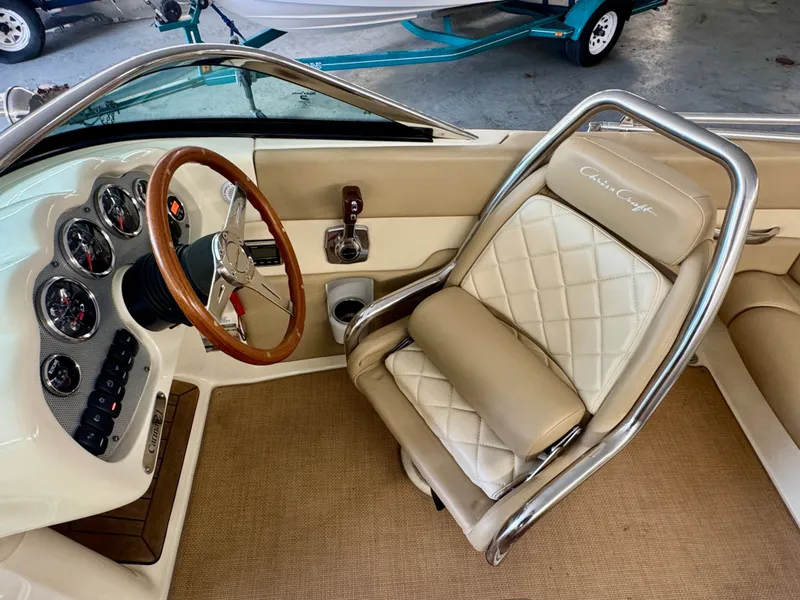 Slide: The Image of The image shows the cockpit of a 2016 Chris-Craft Carina 21 with a stylish steering wheel and cushioned seats. - 25