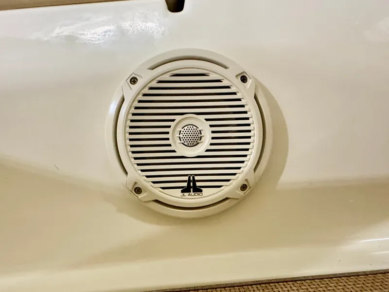 Slide: The Image of A JL Audio speaker is mounted in the white interior panel of a Chris-Craft Carina 21 boat. - 33
