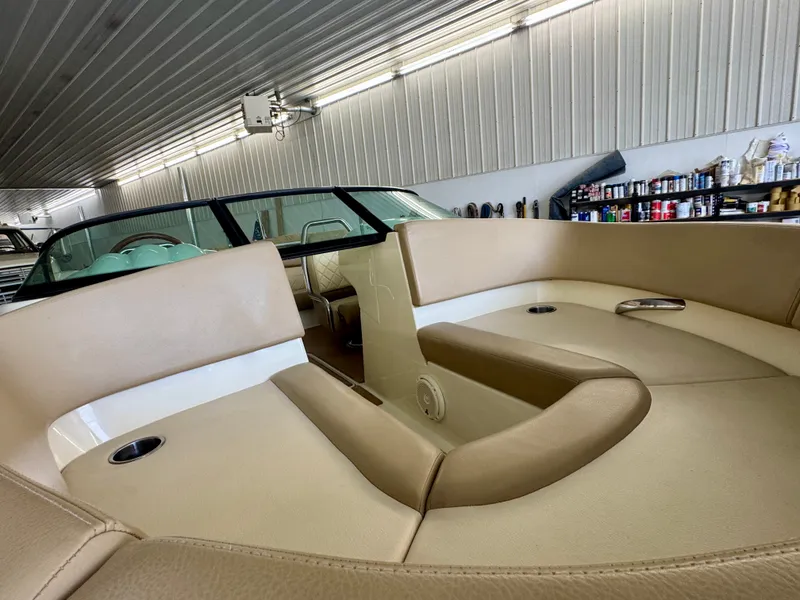 Slide: The Image of Interior view of a 2016 Chris-Craft Carina 21 with beige leather seats in a warehouse. - 32
