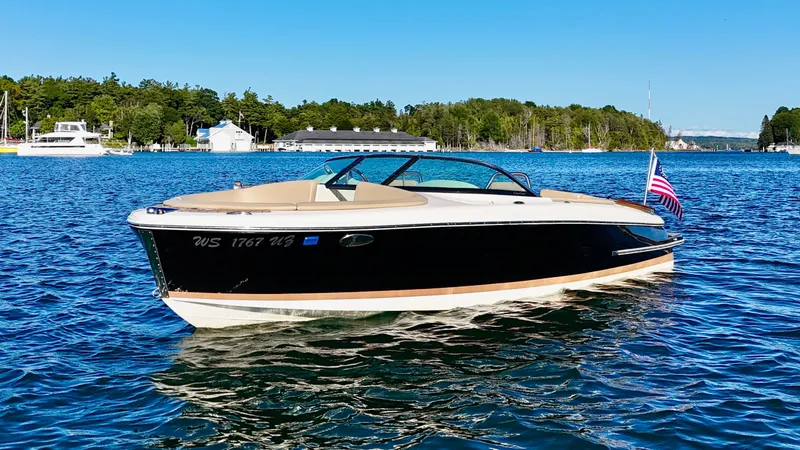 The Image of A sleek 2016 Chris-Craft Carina 21 boat floats on calm water under a clear sky. - 0