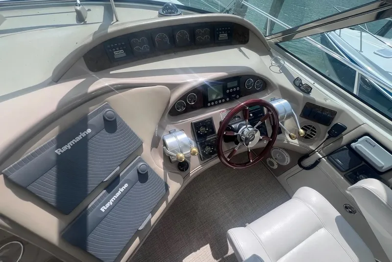 Slide: The Image of 1998 Sea Ray Sundancer 540 helm with Raymarine navigation, steering wheel, and control panels. - 37
