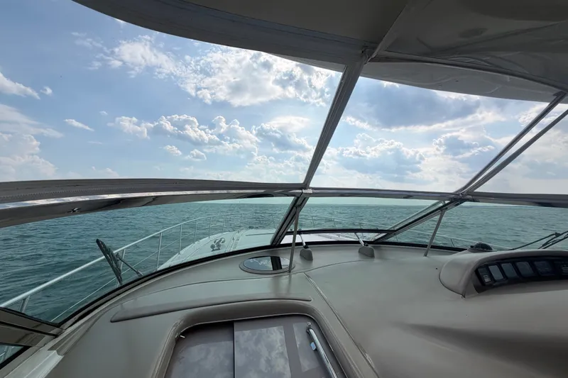 Slide: The Image of 1998 Sea Ray Sundancer 540 yacht cruising on open water under a partly cloudy sky. - 29