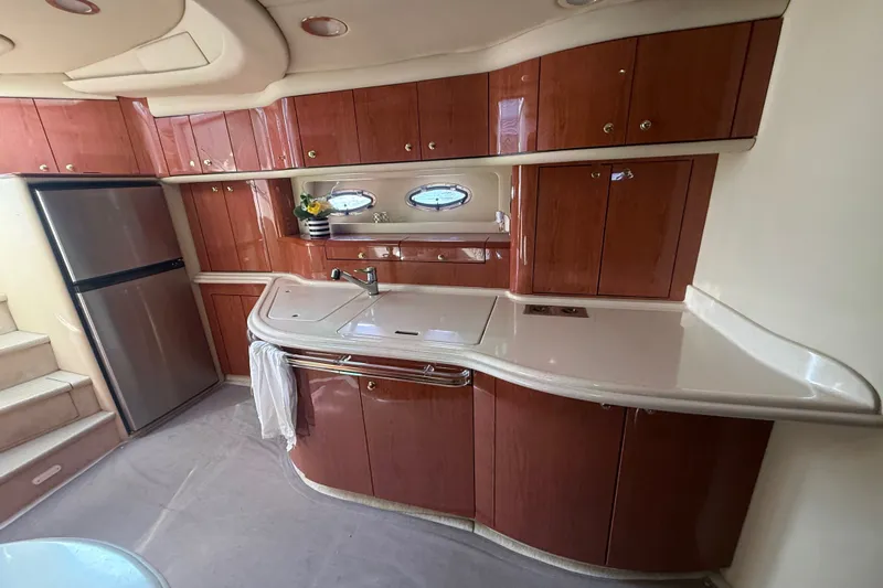 Slide: The Image of Luxurious kitchen interior of 1998 Sea Ray Sundancer 540 yacht with wood cabinetry and modern appliances. - 22