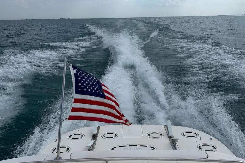 Slide: The Image of American flag on a 1998 Sea Ray Sundancer 540 cruising through ocean waves. - 25