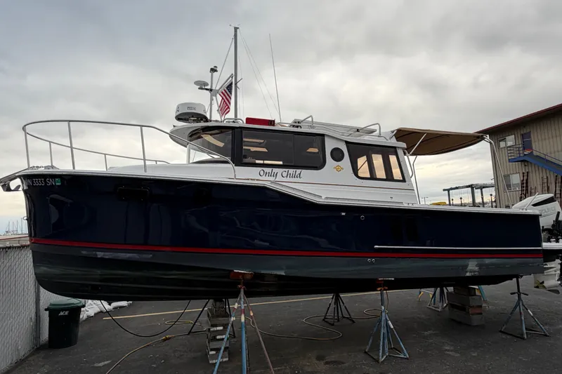 The Image of 2018 Ranger Tugs R-27 boat on stands, with overcast sky background. - 0