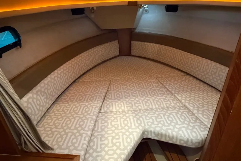 Slide: The Image of 2018 Ranger Tugs R-27 cabin interior with patterned cushions and ambient lighting. - 2