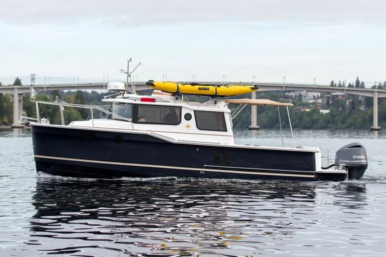 Slide: The Image of Manufacturer Provided Image: 2018 Ranger Tugs R-27 boat cruising on a calm river with a bridge in the background. - 5