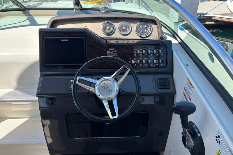 Slide: The Image of Cockpit of 2016 Sea Ray Sundancer 260 with steering wheel and control panel. - 12