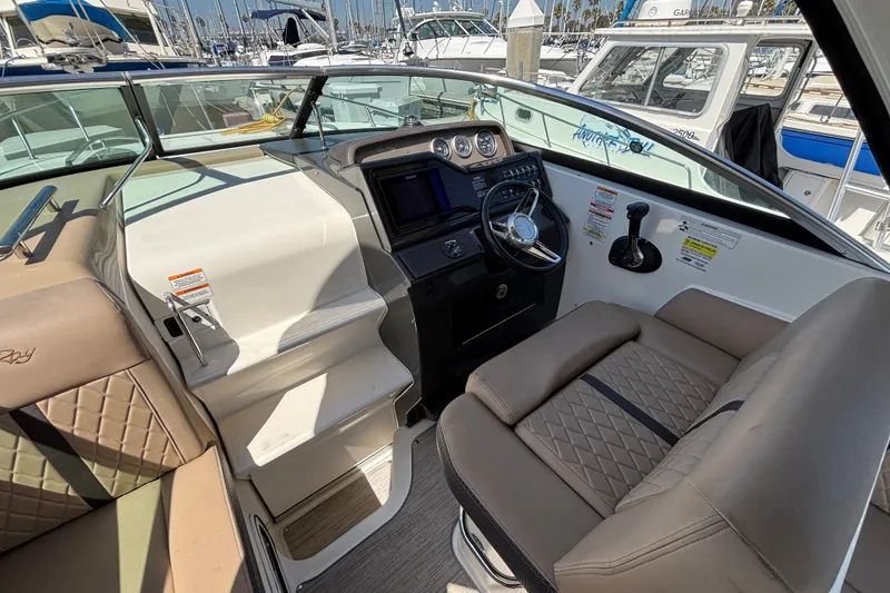 Slide: The Image of 2016 Sea Ray Sundancer 260 cockpit with steering wheel, gauges, and comfortable seating. - 11