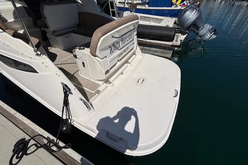 Slide: The Image of 2016 Sea Ray Sundancer 260 docked, showcasing spacious swim platform and seating area. - 4