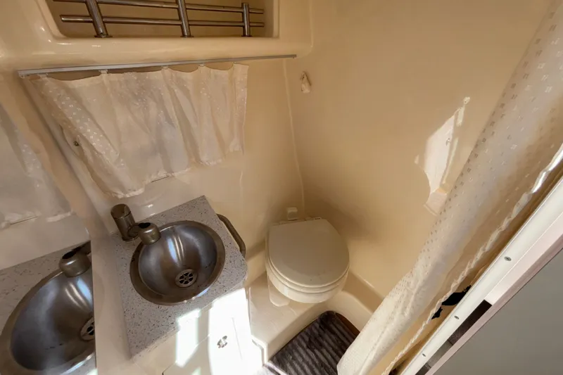 Slide: The Image of Compact bathroom in 2016 Sea Ray Sundancer 260 with sink, toilet, and shower curtain. - 17
