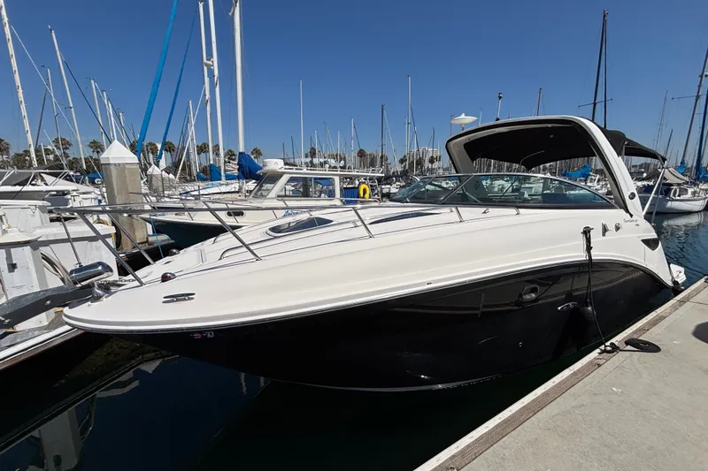 The Image of 2016 Sea Ray Sundancer 260 docked at a marina under clear blue skies. - 1