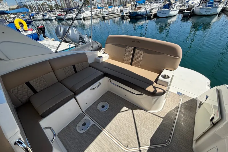 Slide: The Image of 2016 Sea Ray Sundancer 260 interior with plush seating, docked at a marina. - 8