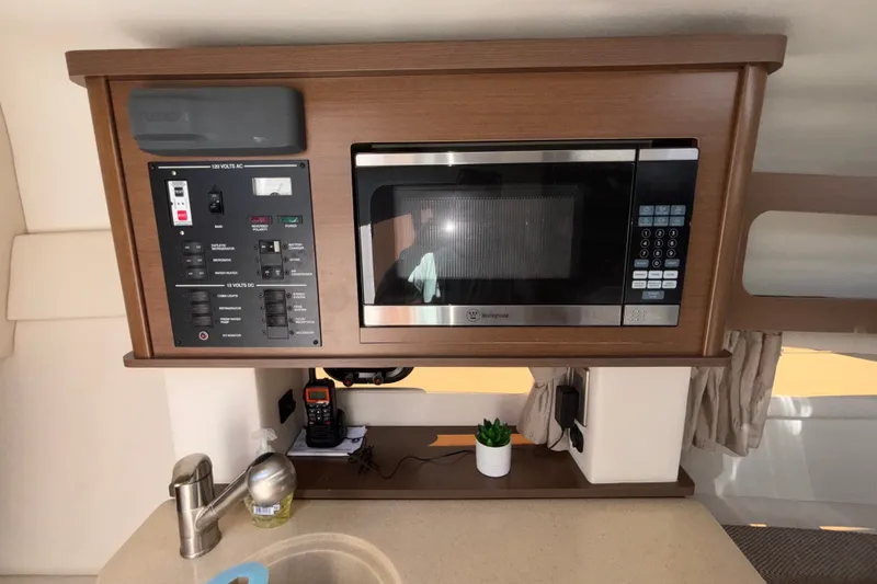 Slide: The Image of Interior of 2016 Sea Ray Sundancer 260 featuring microwave and control panel. - 15