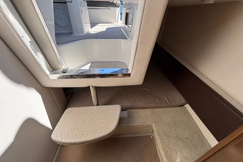 Slide: The Image of Interior cabin view of a 2016 Sea Ray Sundancer 260 boat, featuring a compact sleeping area. - 19