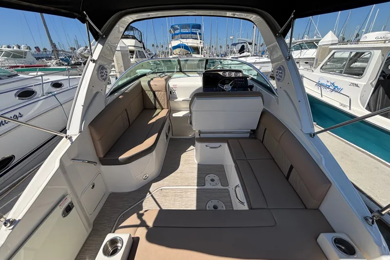 Slide: The Image of 2016 Sea Ray Sundancer 260 interior with beige seating, docked at marina. - 7