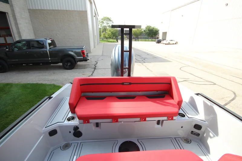 Slide: The Image of 2027 IRON BOATS 707 T-top with red seating, parked near industrial buildings. - 14