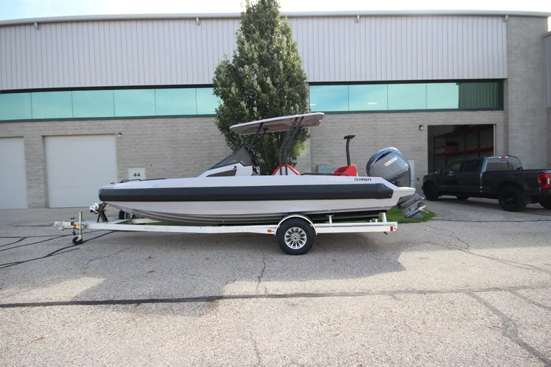 The Image of 2027 IRON BOATS 707 T-top on trailer outside industrial building. - 1