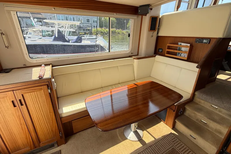 Slide: The Image of Interior of 2012 American Tug 365 with wooden table and cream seating. - 77