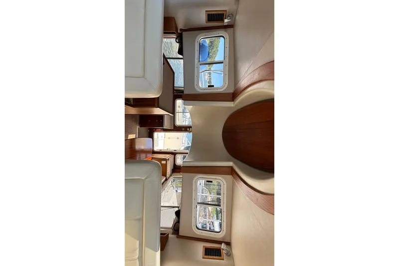 Slide: The Image of Interior view of 2012 American Tug 365, showcasing windows and seating area. - 140