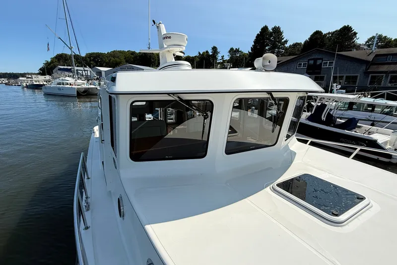 Slide: The Image of 2012 American Tug 365 docked at marina, showcasing cabin and windows. - 12