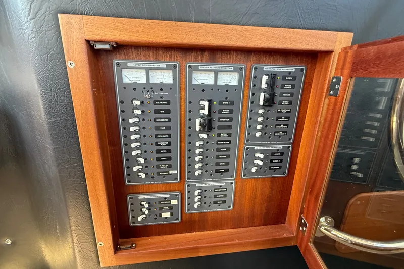 Slide: The Image of Electrical panel of a 2012 American Tug 365 boat, featuring switches and meters. - 84