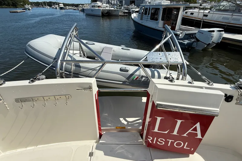Slide: The Image of American Tug 365 (2012) with dinghy on davit, docked at marina. - 38