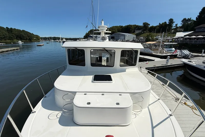Slide: The Image of 2012 American Tug 365 docked at a marina, showcasing its spacious deck and sleek design. - 10