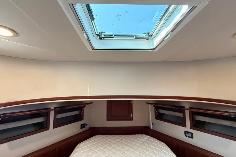 Slide: The Image of Cozy cabin interior of 2012 American Tug 365 with skylight and quilted bed. - 117