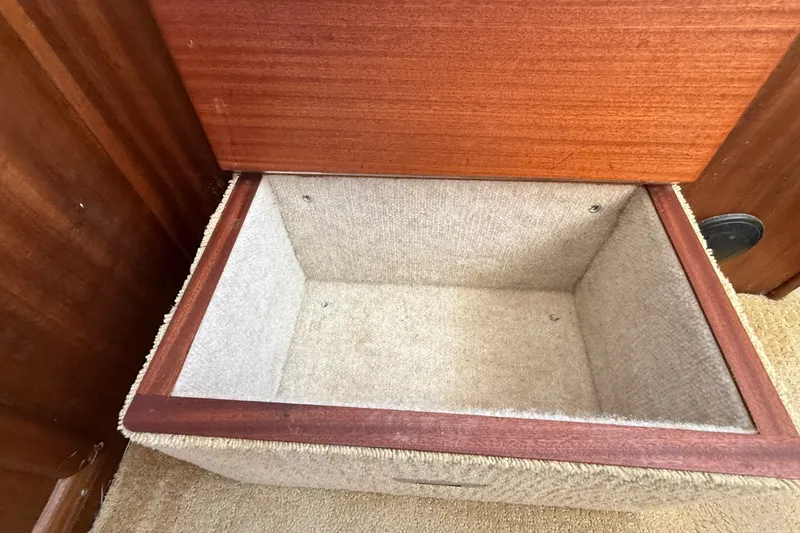 Slide: The Image of Storage compartment in 2012 American Tug 365 boat, featuring wooden and carpeted interior. - 105