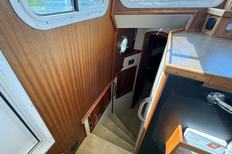 Slide: The Image of Interior stairs of 2012 American Tug 365, featuring wood paneling and nautical design elements. - 108