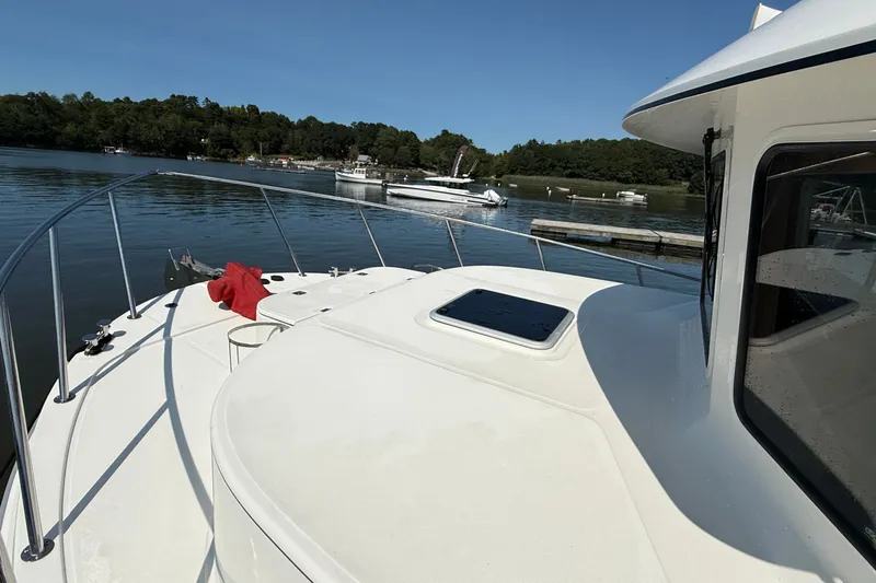 Slide: The Image of American Tug 365 (2012) on calm water, showcasing deck and railing. - 2