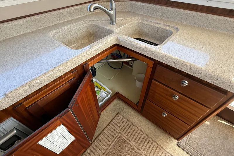 Slide: The Image of Kitchen area of a 2012 American Tug 365 with dual sinks and wooden cabinetry. - 55