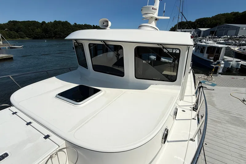 Slide: The Image of American Tug 365, 2012 model, docked at a marina with scenic water view. - 13