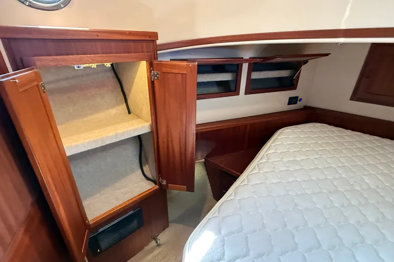 Slide: The Image of Cozy cabin interior of 2012 American Tug 365 with wooden cabinetry and comfortable bedding. - 115