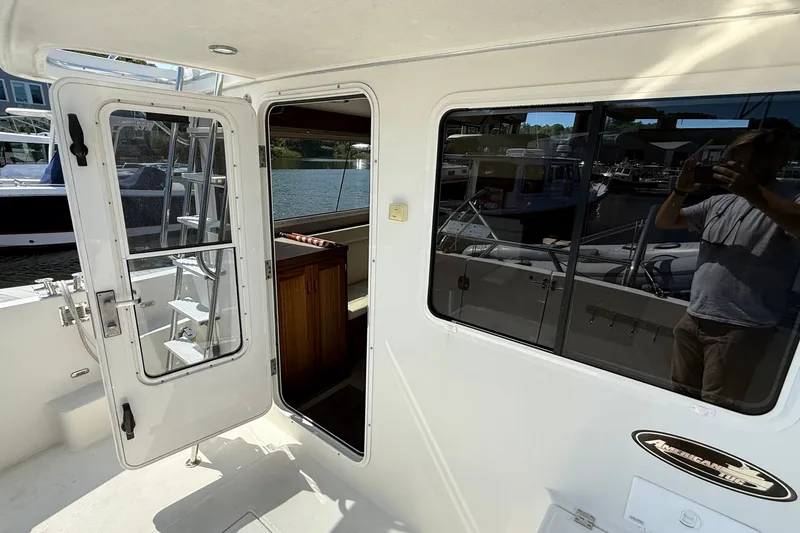 Slide: The Image of American Tug 365 (2012) boat entrance with open door and marina view. - 47