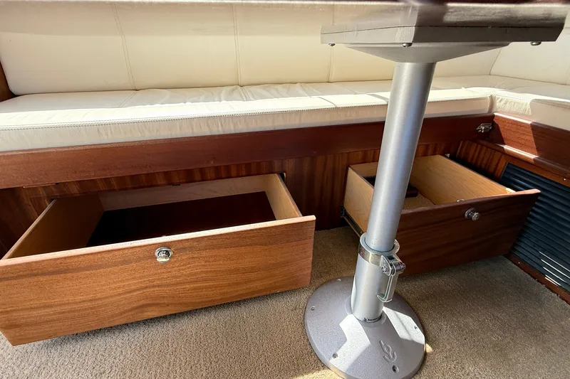 Slide: The Image of Interior of 2012 American Tug 365 with open wooden storage drawers under seating. - 62
